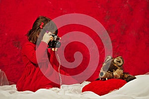 A girl in red using a vintage photo camera