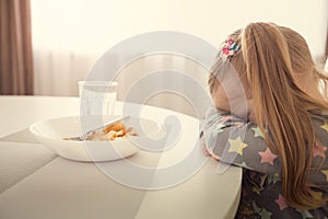 Girl refuses to eat. Child meal difficultes theme.