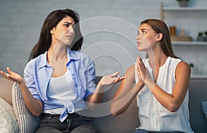 Girl Refusing To Do Favor For Friend Sitting On Sofa photo