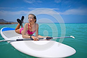 Girl relaxed lying on paddle surf board SUP