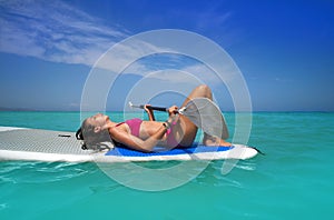 Girl relaxed lying on paddle surf board SUP