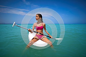 Girl relaxed sitting on paddle surf board SUP