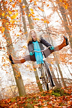 Girl relaxing in autumnal park with bicycle