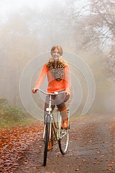 Girl relaxing in autumnal park with bicycle