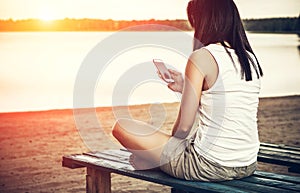 Girl relaxing on the beach with phone