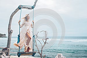 Girl relaxing on beach swings on Bali