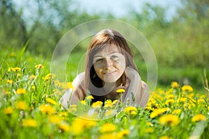 Girl relaxing in dandelion meadow photo