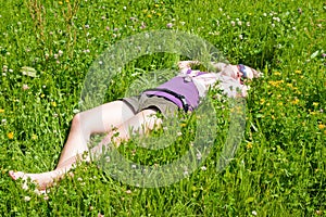Girl relaxing in green meadow