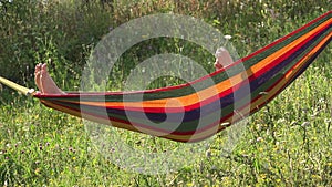 Girl relaxing in hammock, playing a daisy flower in the hands