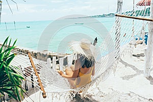 Girl relaxing in hammock in tropical beach cafe