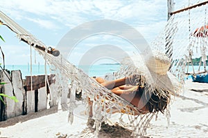 Girl relaxing in hammock in tropical beach cafe