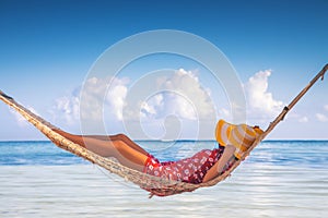 Girl relaxing in a hammock on tropical island beach. Summer vacation in Punta Cana, Dominican Republic