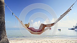 Girl relaxing in a hammock on tropical island beach. Summer vacation in Punta Cana, Dominican Republic