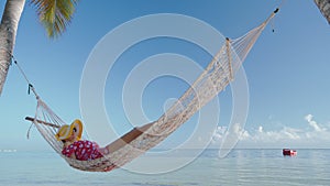 Girl relaxing in a hammock on tropical island beach. Summer vacation in Punta Cana, Dominican Republic