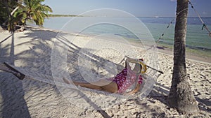 Girl relaxing in a hammock on tropical island beach. Summer vacation in Punta Cana, Dominican Republic