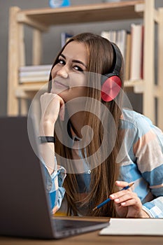 Girl relaxing listen music in headphones thinking idea solitions. Student woman online larning photo