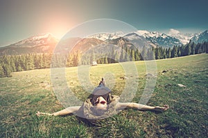 Girl relaxing in mountains view at mountains. Sunny spring landscape.