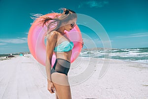 Girl relaxing on pink lilo on the beach