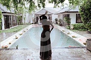 Girl relaxing in the pool on luxury villa in Bali.