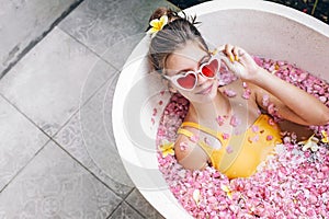 Girl relaxing in spa bath with flowers