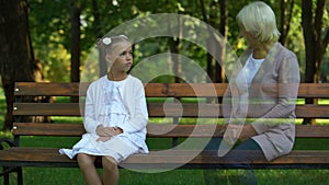 Girl remembering her grandmother, sitting on bench alone, loss of grandparent