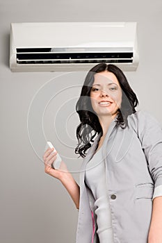 Girl with a remote control air conditioner