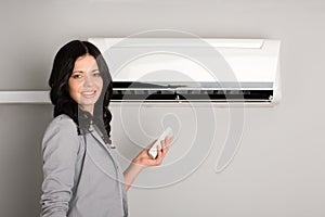 Girl with a remote control air conditioner