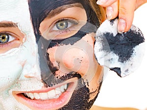 Girl remove black white mud mask from face