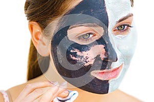 Girl remove black white mud mask from face