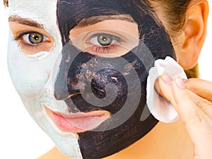 Girl remove black white mud mask from face