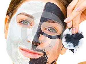 Girl remove black white mud mask from face