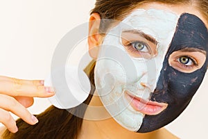 Girl remove black white mud mask from face