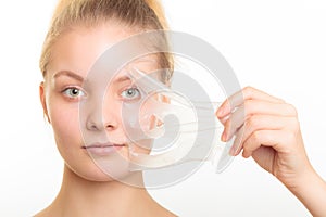 Girl removing facial peel off mask