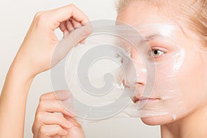 Girl removing facial peel off mask