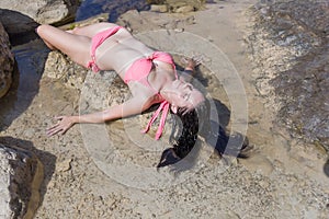 Girl resting on rocky seashore