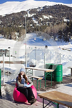 girl resting from skiing in a cafe ski resort at the foot of the mountains