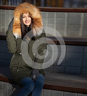 Girl resting on a street autumn bench