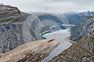 Girl resting on Trolltunga rock. Norwegian mountain landscape