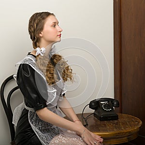 Girl in retro school uniform sitting on chair