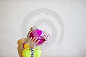 Girl with a rhythmic gymnastics pink ball. Flexibility in acroba