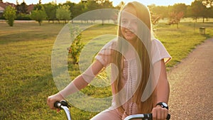 Girl ride bicycle on park alley - close up