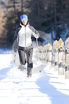 A girl during a ride with snowshoes and poles