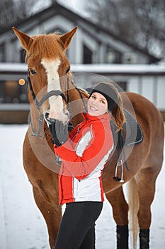 A girl rider trains riding on her horse in the snowy winter
