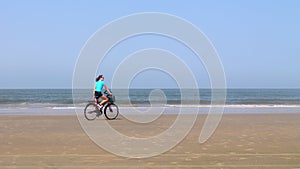 Girl rides a bicycle on the beach