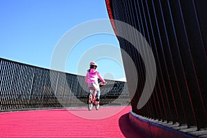 Girl rides bike on pink cycleway in Auckland photo