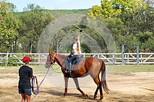 A girl rides a horse to master various elements of horseback riding.