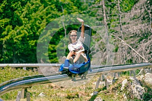 Girl rides a mountain roller coaster and waves