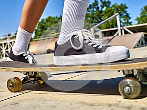 Girl rides on roller skates in skatepark.