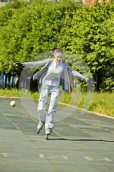 Girl rides on rollers,arms outstretched