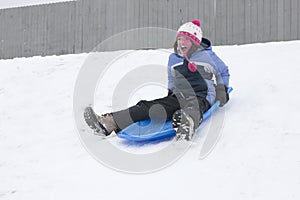 Girl rides on sled.